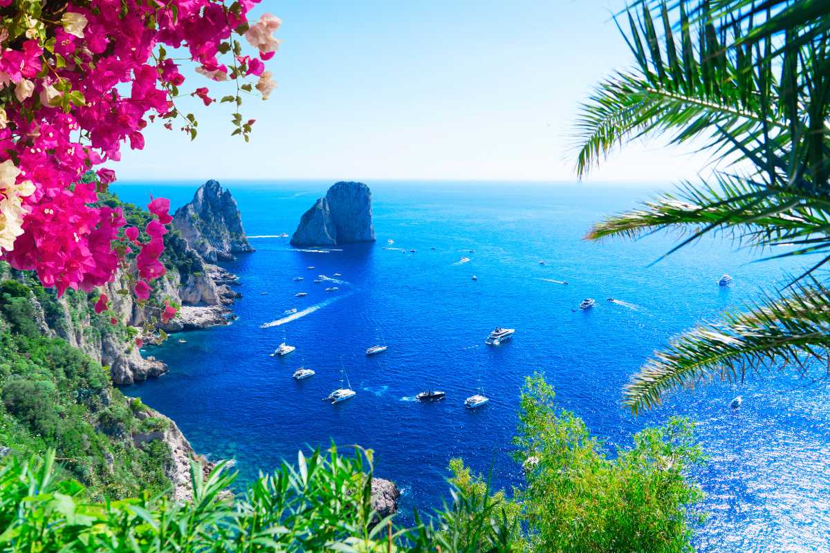 Persone che percorrono il Sentiero degli Dei, panorama spettacolare sulle scogliere e sul mare blu, con Positano sullo sfondo